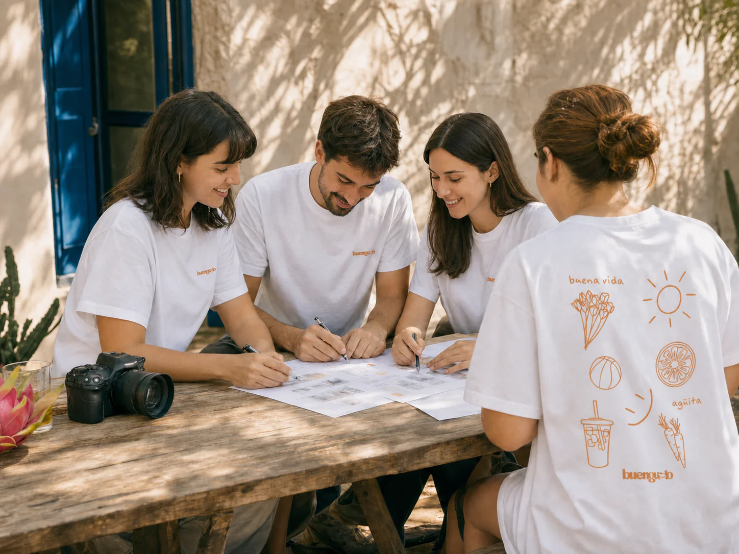 Equipo de Buengusto trabajando alrededor de una mesa con sus camisetas originales